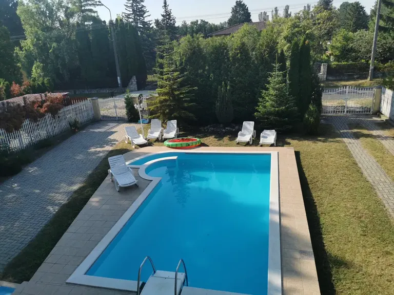 Medence és napozóágyak a kertben